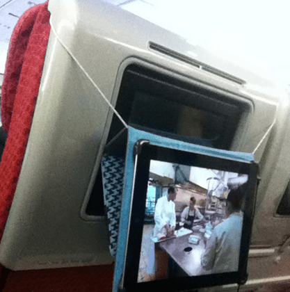 tablet hooked to the back of an airplane seat